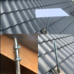 Yehor Chebotar - Antena satelitarna zamontowana na dachu z czarnej dachówki, widok z góry. Metalowe mocowania i maszt anteny. Ujęcie z bliska na detale instalacji.