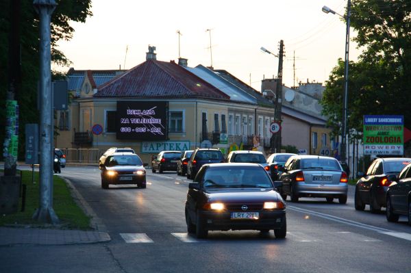 Telebim reklamowy z tekstem 'Reklama na telebimie' umieszczony na budynku przy ruchliwej ulicy z samochodami w Rykach przy trasie K17 Lublin-Warszawa.