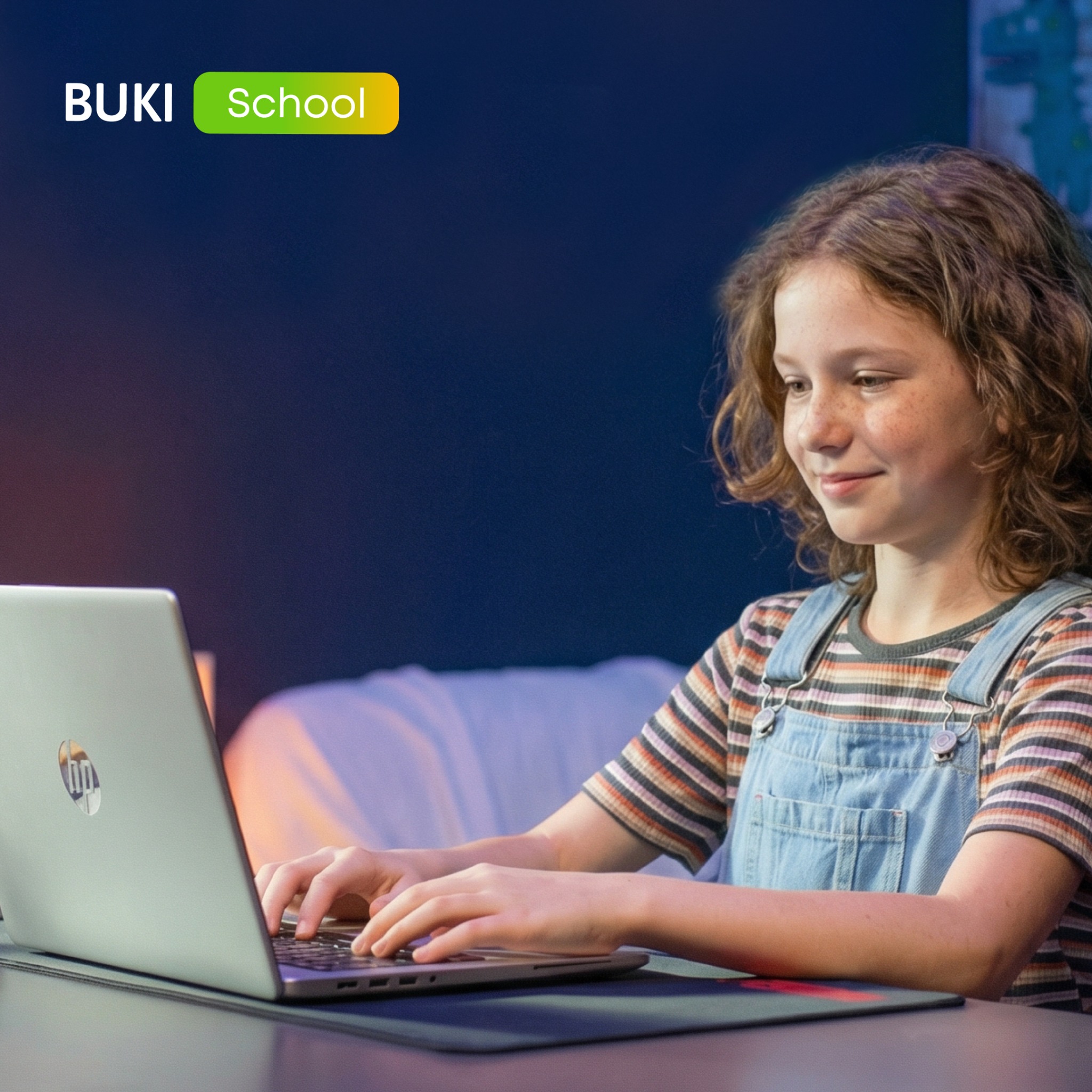 Dziewczynka z piegami uśmiecha się, pisząc na laptopie. W tle logo BUKI School. Nauka online dla dzieci w domowym zaciszu. Stonowane oświetlenie.