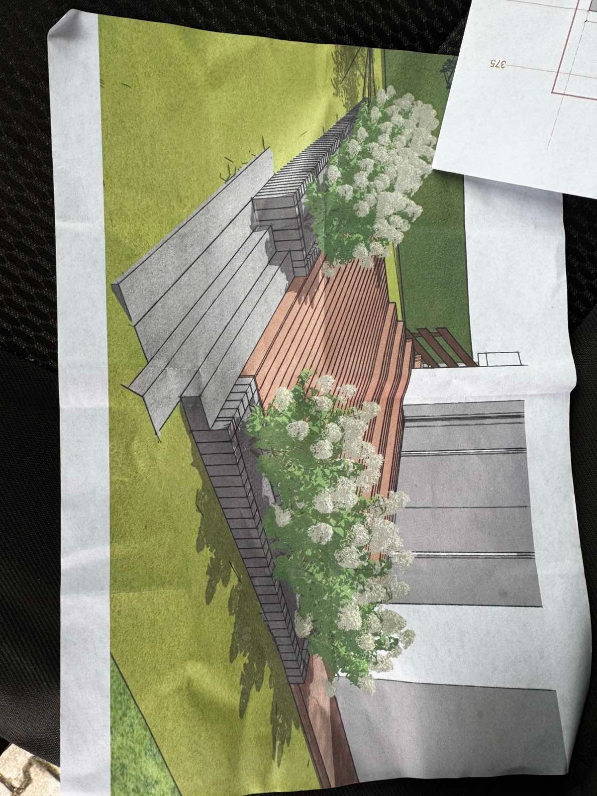 Szkic koncepcyjny zagospodarowania terenu z elementami drewnianymi, zielenią i schodami, przedstawiony na papierze z widocznymi zagnieceniami.