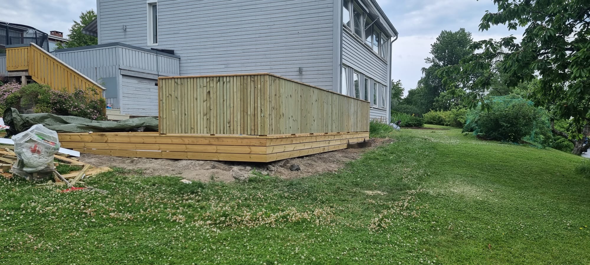 Dwupoziomowy taras z barierkami oraz przygotowanym miejscem pod basen.