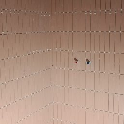 Łazienka w trakcie wykańczania: pionowo ułożone, podłużne, różowe płytki z białymi krzyżykami dystansowymi. Widoczne wyprowadzenia instalacji wodnej.