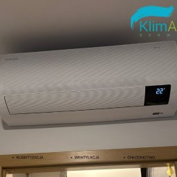 KlimArt-Serwis Klimatyzacja - Biały klimatyzator Samsung WindFree zamontowany nad futryną drzwiową z napisem: Klimatyzacja, Wentylacja, Chłodnictwo. Na wyświetlaczu klimatyzatora widoczna temperatura 22 stopnie.