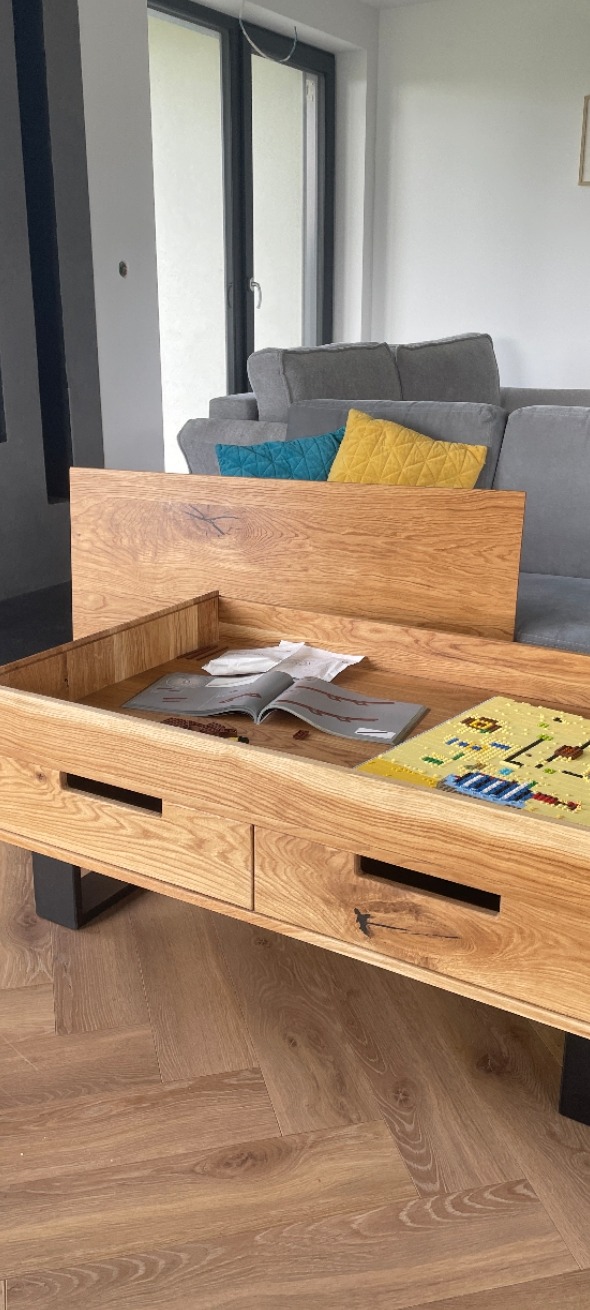 Drewniany stolik kawowy z szufladami i blatem w formie tacy, na czarnych nogach, w salonie. Wykonany na zamówienie w Olsztynie.