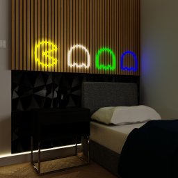 Chicc Interiors - Pokój z łóżkiem, szafką nocną i dekoracją ścienną z drewnianych paneli z neonami w kształcie duszków Pac-Mana. Nowoczesny design, stonowana kolorystyka.