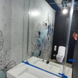 DKHOUSE - Nowoczesna łazienka w Łodzi z umywalką wpuszczaną w blat, lustrem w metalowej ramie i dekoracyjną tapetą. Widoczne rury pod sufitem.