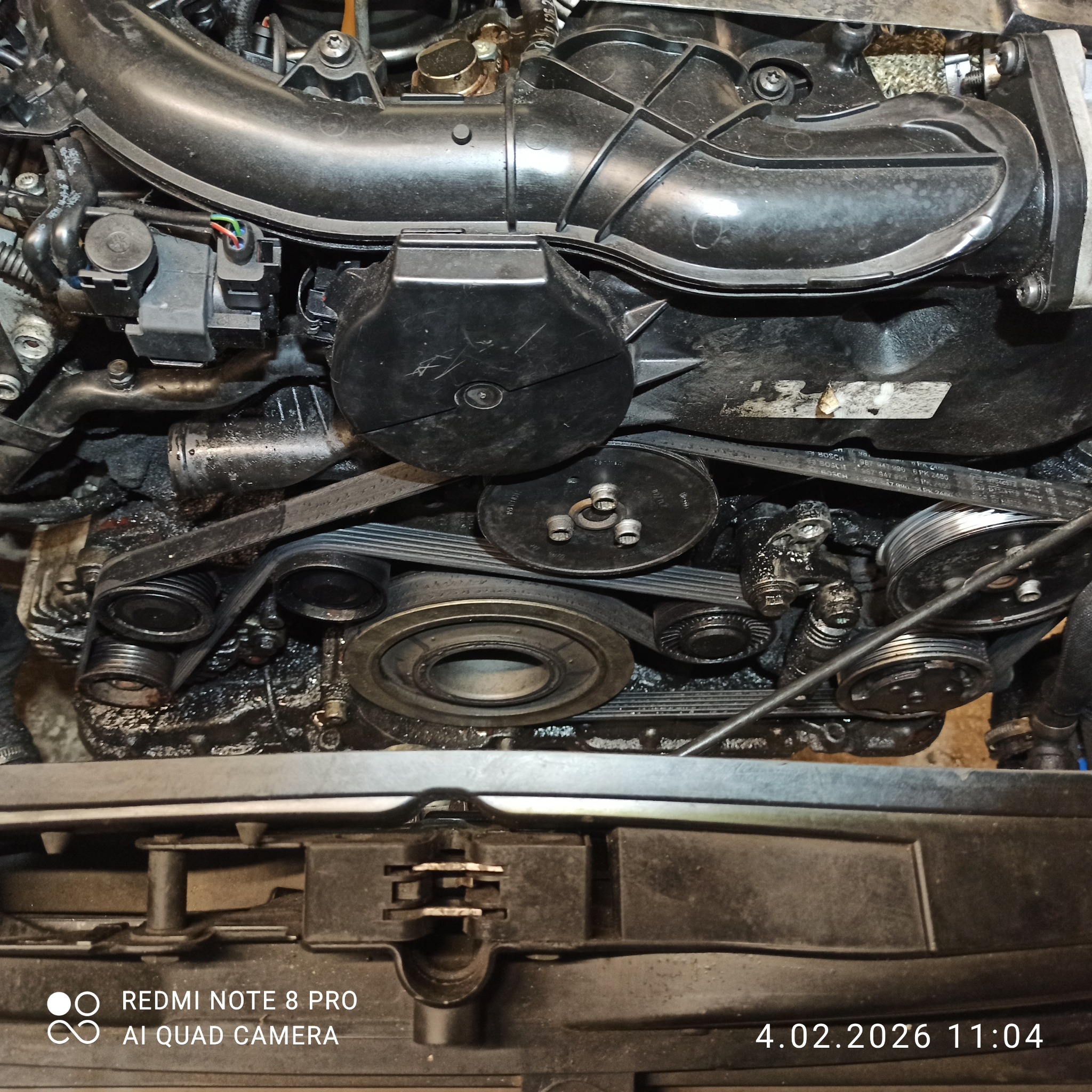 Silnik samochodowy z widocznym paskiem klinowym i elementami osprzętu w Nowostawach Dolnych. Detaliczny widok na mechanizm napędowy.