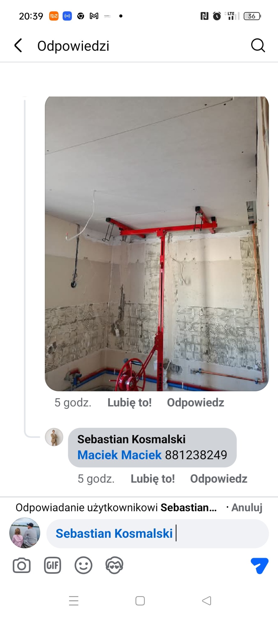 Montaż płyty karton gips na suficie za pomocą podnośnika. Widoczne instalacje na ścianach. Prace wykończeniowe w trakcie realizacji. Czerwony podnośnik do płyt.
