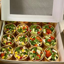 KRAKPRESS SPÓŁKA Z OGRANICZONĄ ODPOWIEDZIALNOŚCIĄ - Zestaw 12 porcji sałatek w papierowych kubeczkach, ułożonych w pudełku z okienkiem. Różne kompozycje: kurczak, kukurydza, pomidor, ogórek, rukola, ser.