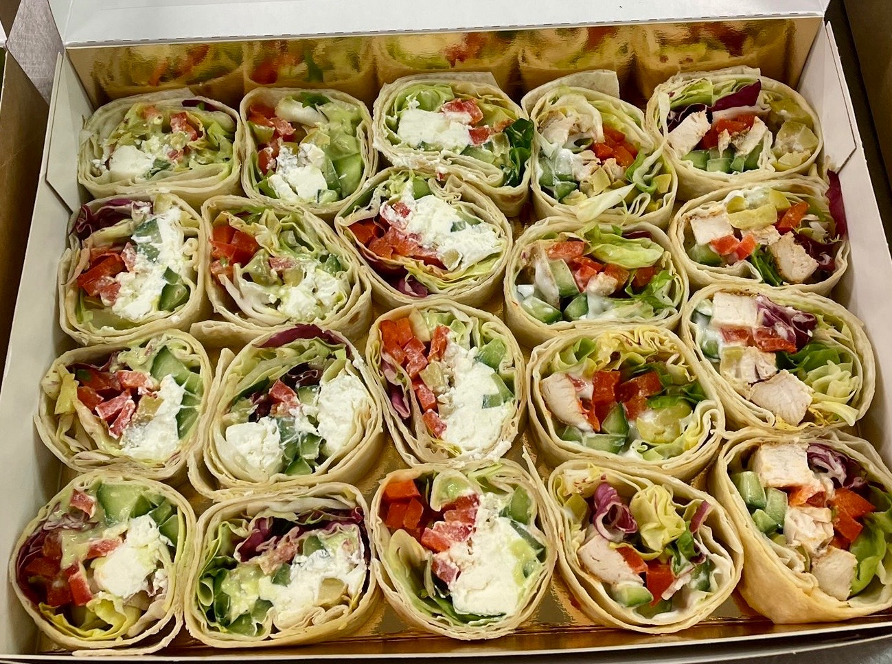 Tortille z kurczakiem, serem i warzywami w pudełku cateringowym. Różne nadzienia, świeże składniki, estetyczna prezentacja. Idealne na firmowe lunche.