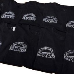 PATI-HAFT MARZENNA POŁETEK - Czarne koszulki z białym haftem logo 'DEJV CARS Dawid Soliński' ułożone na sobie. Widoczne detale haftu i materiału. Prezentacja nadruków na odzieży.