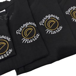 PATI-HAFT MARZENNA POŁETEK - Czarne koszulki z haftowanym logo 'Pierogowa Marta' w kolorach białym i złotym, ułożone obok siebie. Widoczne detale haftu i materiału.