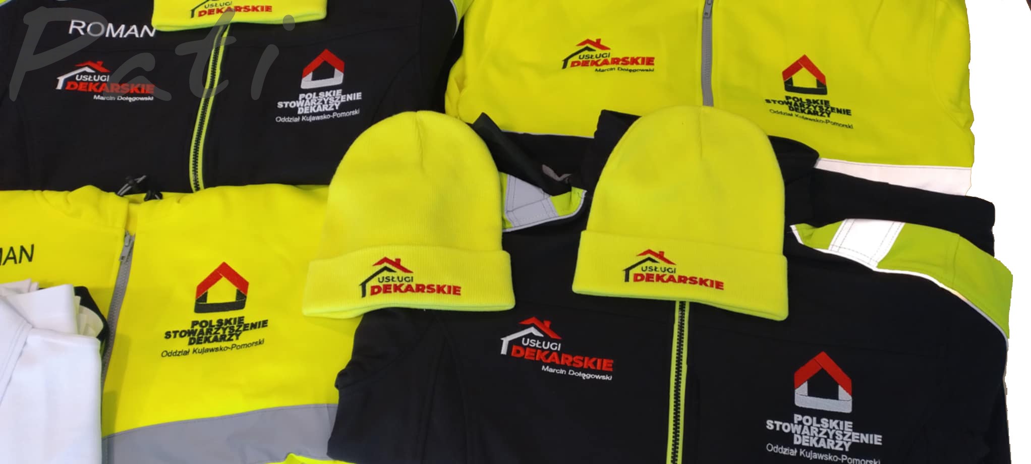 Żółto-czarne kurtki i czapki z haftowanym logo firmy dekarskiej. Odzież robocza z wyraźnym brandingiem, ułożona na płasko. Widoczne detale haftu i odblaskowe elementy.