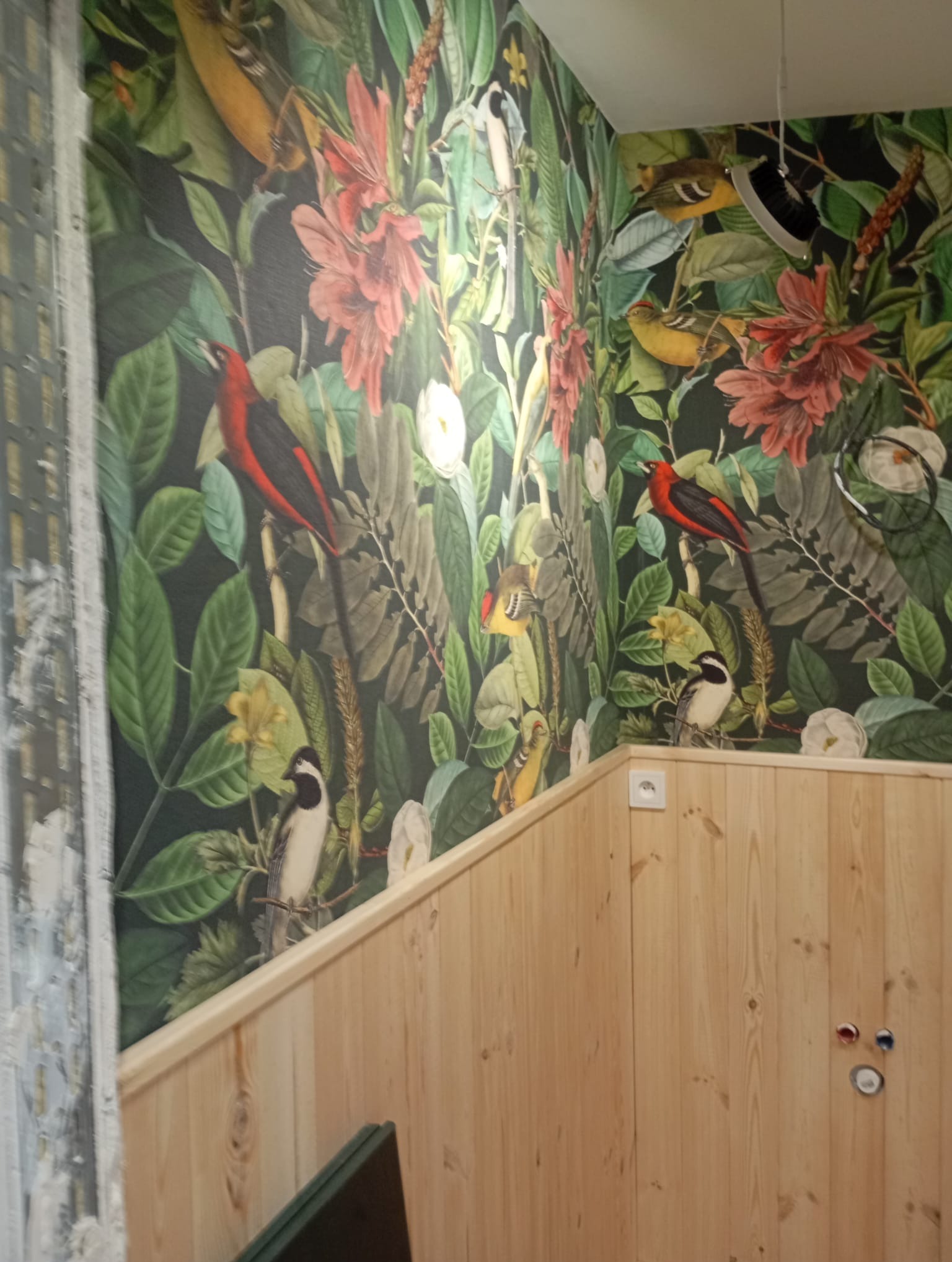Wnętrze po malowaniu w Tarnowie: ściana z motywem tropikalnych ptaków i kwiatów, drewniana boazeria. Dekoracyjne wykończenie wnętrza.