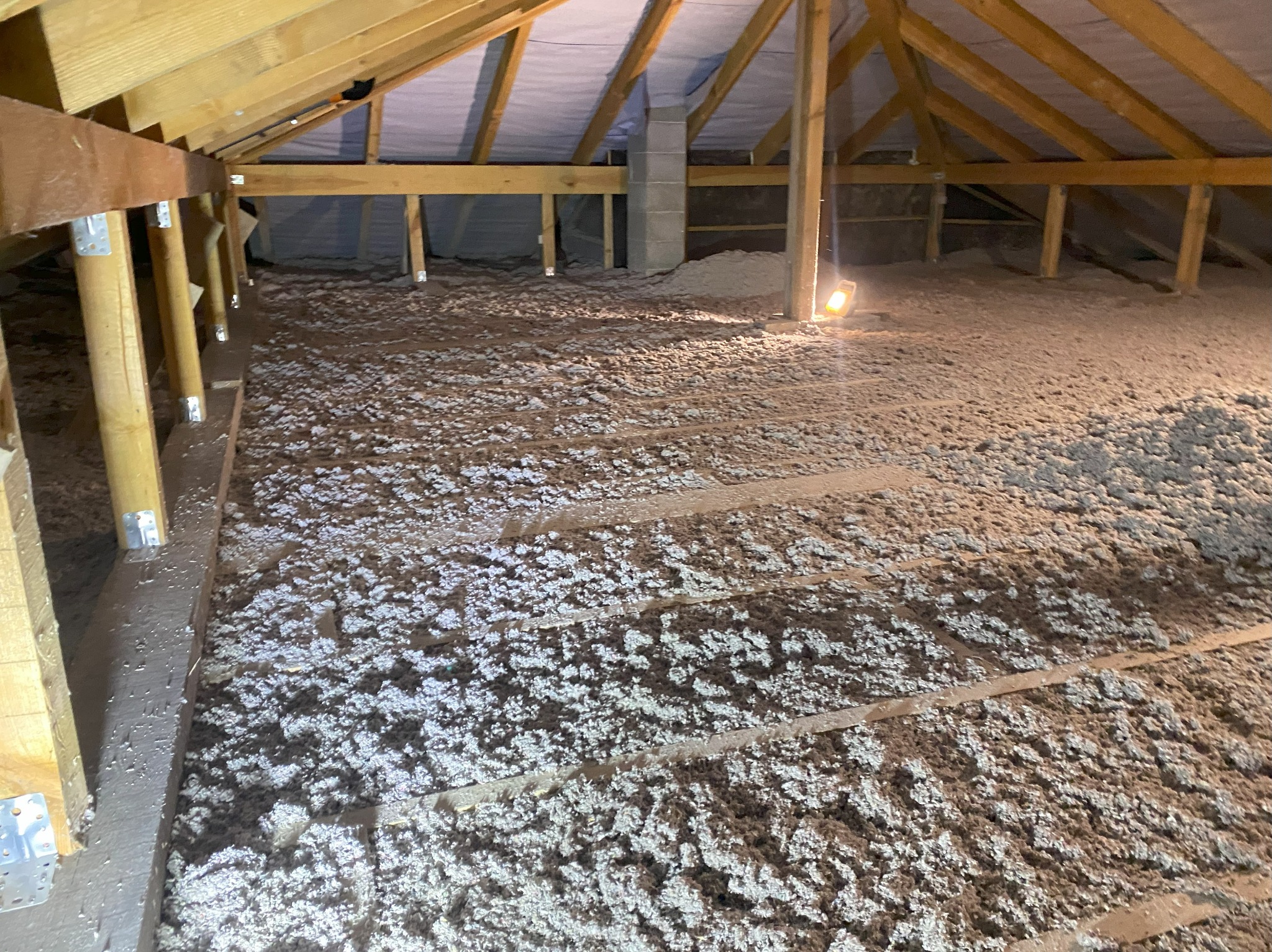 Poddasze z widoczną izolacją z wełny mineralnej, drewniana konstrukcja dachu, oświetlenie punktowe. Izolacja termiczna poddasza w trakcie realizacji.