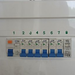 Piotr Wruk Usługi Elektryczne - Rozdzielnica elektryczna z ośmioma bezpiecznikami, każdy oznaczony numerem od 1 do 8. Bezpieczniki marki LCTEC, z niebieskimi przełącznikami w pozycji OFF.