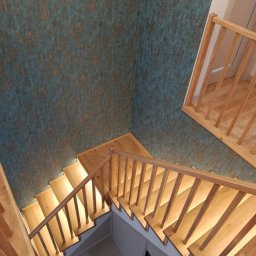 Kamil jonca - Nowoczesne schody z jasnego drewna z podświetleniem LED, widok z góry. Dekoracyjna ściana w tle. Minimalistyczny design i precyzyjne wykonanie.