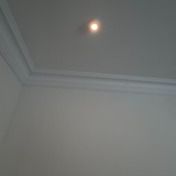 KONOTOP-BUD VIKTOR KONOTOPCHYK - Białe ściany z dekoracyjnym gzymsem sufitowym i punktowym oświetleniem. Minimalistyczne wykończenie wnętrza, widok z dołu.