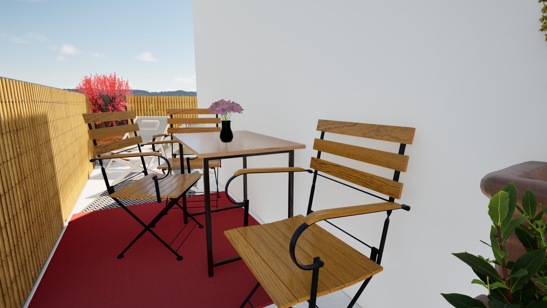 Kameralny balkon z bambusową osłoną, czerwonym dywanem i drewnianymi meblami ogrodowymi. Na stole wazon z kwiatami. Widok na drzewa w oddali.