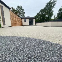 Zywice.pro - Nowoczesny taras z żywicy epoksydowej w dwóch odcieniach szarości, z budynkiem w tle, Gostynin. Unikalny wzór i gładka powierzchnia.