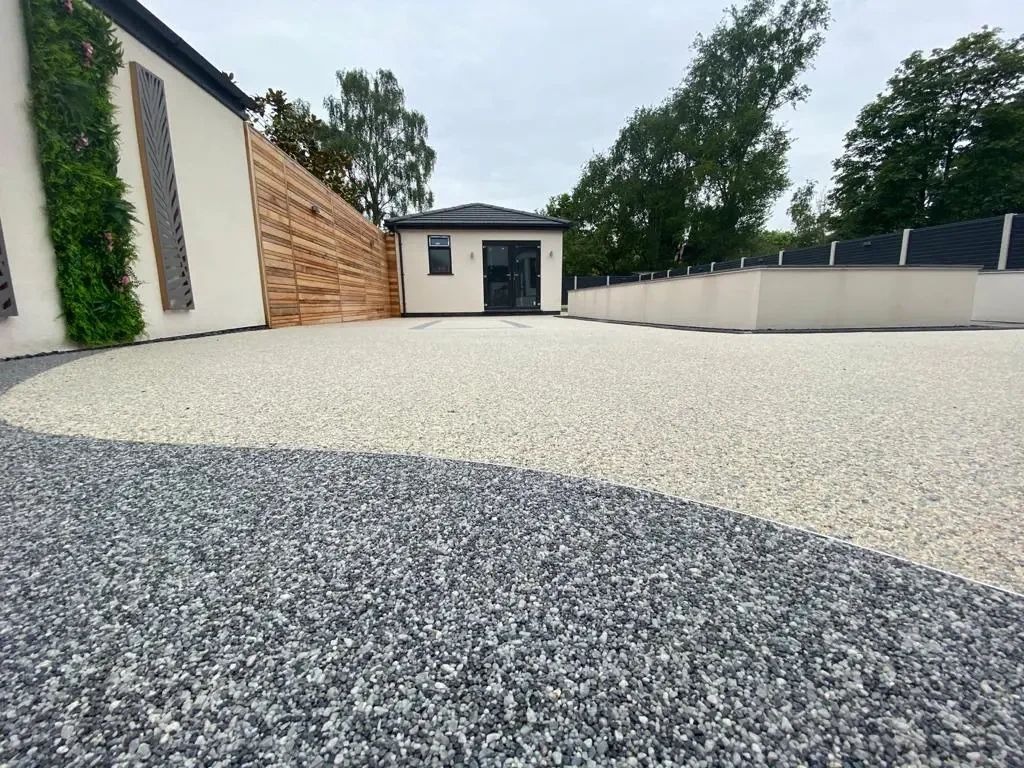 Nowoczesny taras z żywicy epoksydowej w dwóch odcieniach szarości, z budynkiem w tle, Gostynin. Unikalny wzór i gładka powierzchnia.