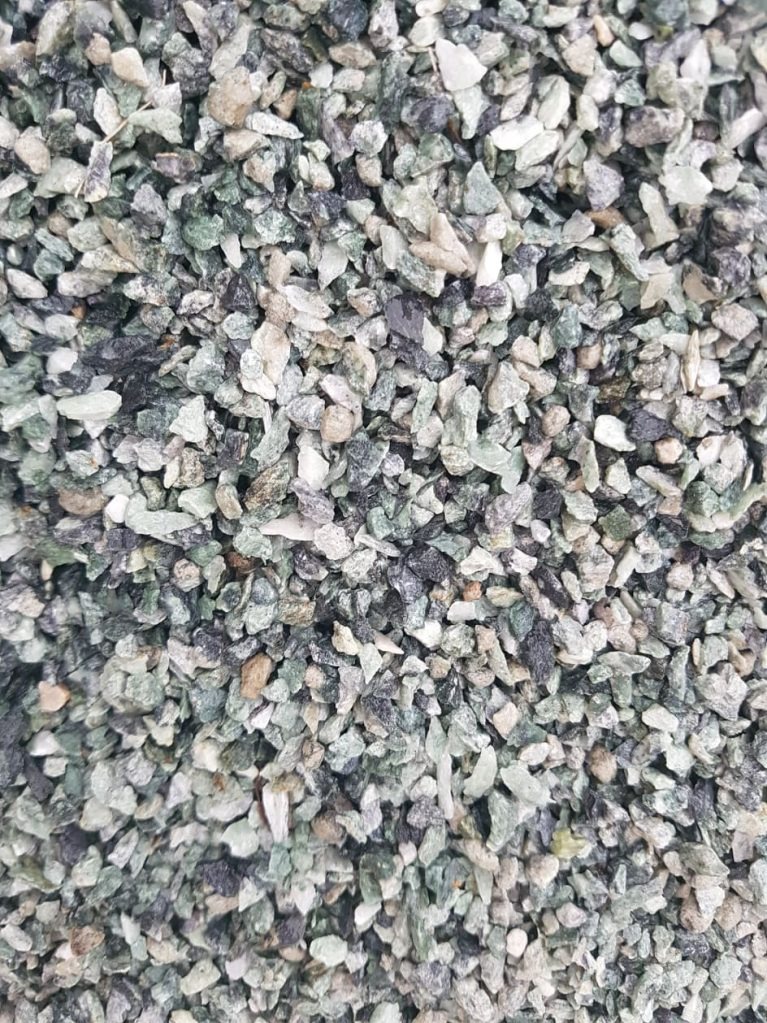 Drobne, zielono-szare kamyczki marmurowe, idealne do dekoracji tarasu lub jako element wykończeniowy schodów. Naturalny kamień w zbliżeniu.