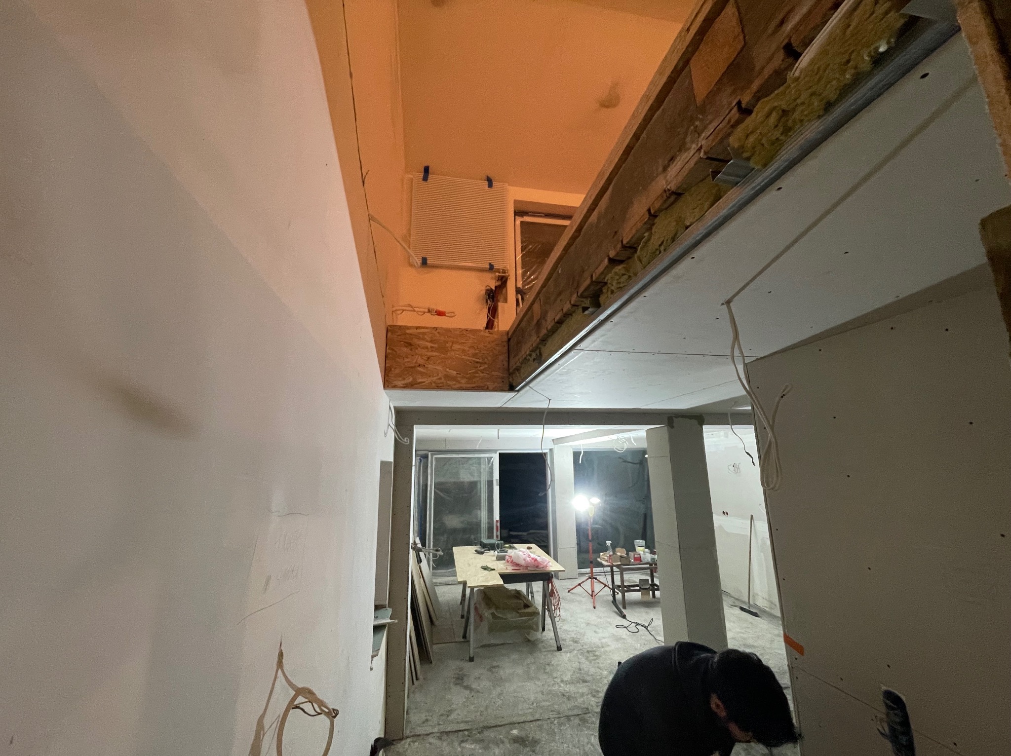 Wnętrze w trakcie remontu: widoczne profile sufitu podwieszanego, instalacje elektryczne, ściany przygotowane do malowania. Prace wykończeniowe w domu z elementami XXw.