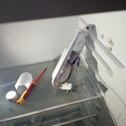 ELEKTRO AL SPÓŁKA Z OGRANICZONĄ ODPOWIEDZIALNOŚCIĄ - Wnętrze lodówki w trakcie naprawy w Liśnicy. Widoczne elementy elektryczne, śrubokręt i regulator temperatury na szklanej półce. Ujęcie z góry, oświetlenie dzienne.