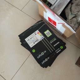 Elektro AL - Opakowania taśm LED COB marki Ecolight, leżące obok otwartego kartonu z innymi produktami. Widoczne etykiety z parametrami technicznymi i logo producenta.