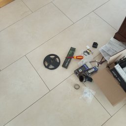 Elektro AL - Rozłożone na podłodze narzędzia i akcesoria do montażu oświetlenia LED: taśma LED, zasilacz, sterownik, wkrętak i elementy montażowe. Widok z góry.