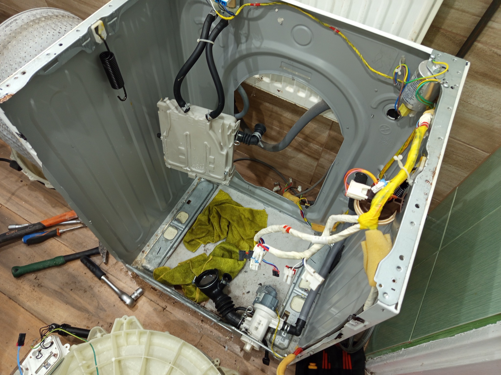 Wnętrze rozmontowanej pralki Samsung z widocznymi elementami: bęben, grzałka, łożyska, narzędzia. Układ wnętrza w trakcie naprawy w Barwicach, woj. zachodniopomorskie.