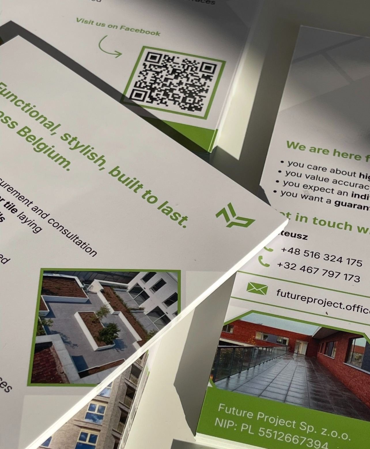 Stos wizytówek firmy Future Project Sp. z o.o. z kodem QR, danymi kontaktowymi i zdjęciami zrealizowanych projektów architektonicznych, w zielono-białej kolorystyce.
