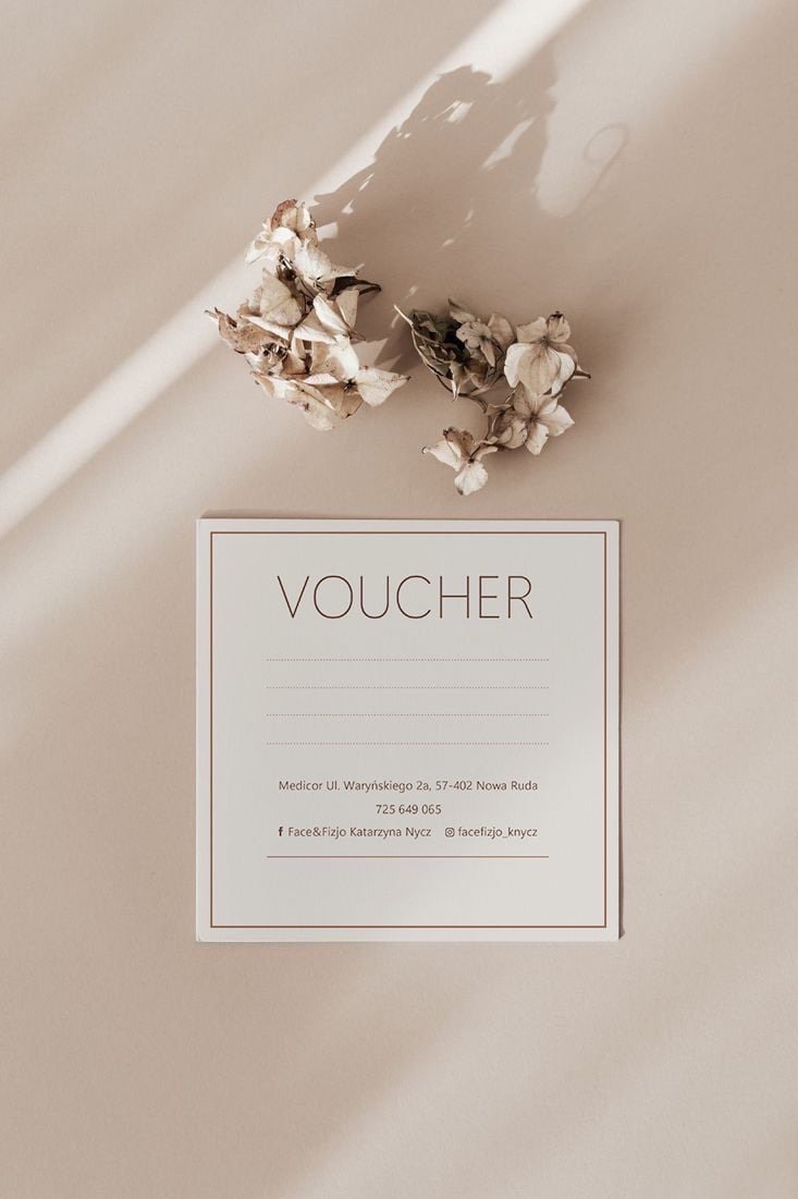 Elegancki voucher na beżowym tle, ozdobiony suszonymi kwiatami i subtelnym cieniem, prezentujący dane firmy Face&Fizjo Katarzyna Nycz z Nowej Rudy.