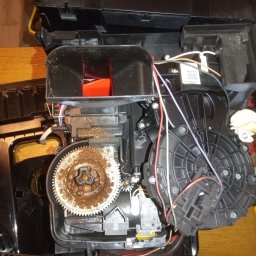 FIXIT SERWIS - Wnętrze rozmontowanego ekspresu do kawy z widocznymi elementami mechanicznymi, przewodami i narzędziami, sugerujące etap naprawy lub konserwacji urządzenia.