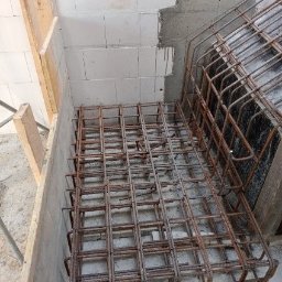 Wladyslaw Chepeluiev - Siatka zbrojeniowa w szalunku, przygotowana do zalania betonem. Widoczne bloczki betonowe w tle. Kąt ujęcia z góry, podkreślający regularność siatki.