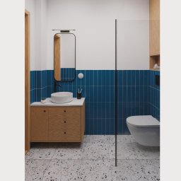 Kwartał Studio Projektowe Mateusz Bidas - Nowoczesna łazienka z niebieskimi płytkami, drewnianą szafką pod umywalką i podłogą w stylu lastryko. Minimalistyczne lustro i kabina prysznicowa ze szkła.