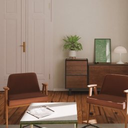 Kwartał Studio Projektowe Mateusz Bidas - Stylowe wnętrze z drewnianą podłogą, brązowymi fotelami i białym stolikiem kawowym. Na komodzie roślina doniczkowa i plakat z mapą miasta Byton.