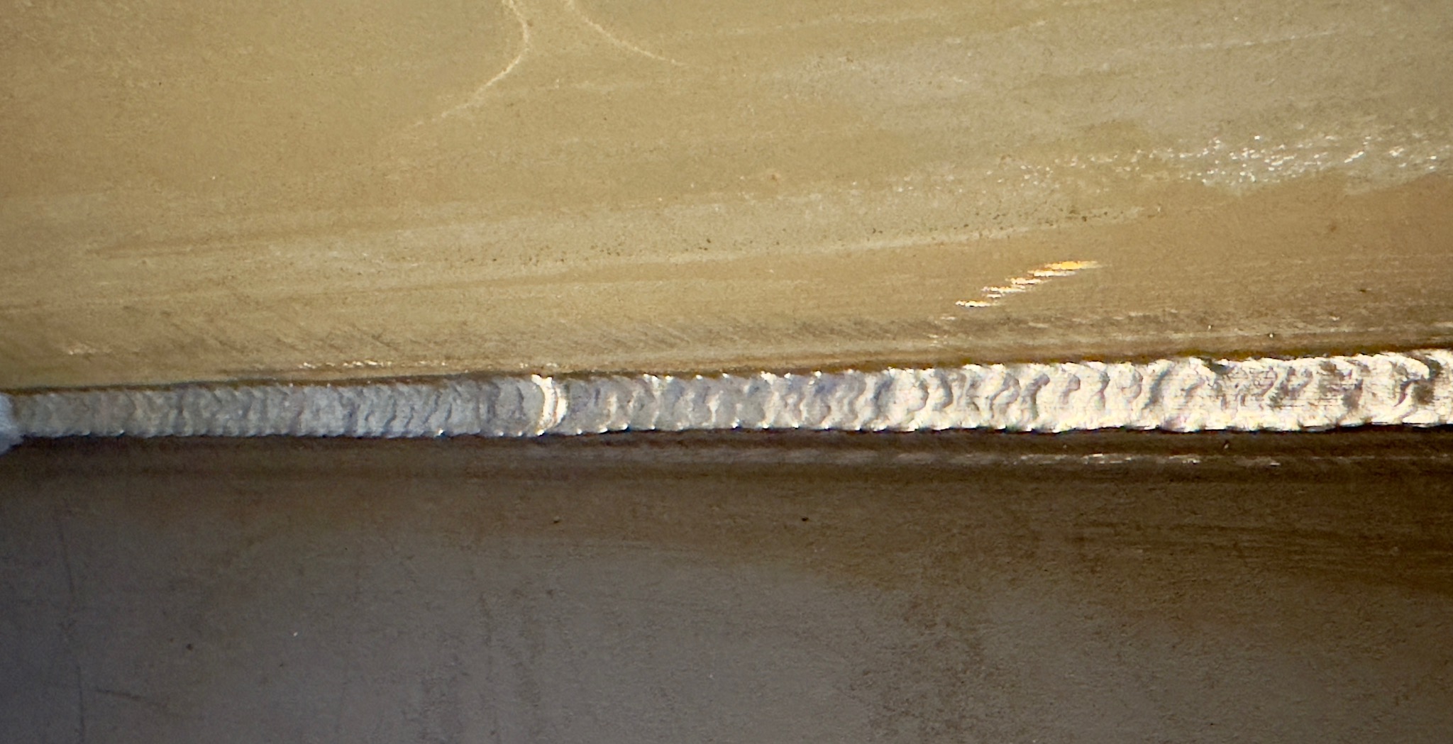 Szczegółowe zbliżenie na spoinę łączącą dwie metalowe powierzchnie, ukazujące precyzję i jakość wykonania. Widoczne nieregularności spoiny podkreślają rzemieślniczy charakter.