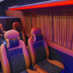 Busem do Celu do Niemiec, Holandii i Belgii, a także powroty do Polski z tych krajów - Luksusowe wnętrze busa z brązowo-czarnymi skórzanymi fotelami, pikowaną tapicerką i nastrojowym oświetleniem LED. Zasłony w oknach dodają prywatności.