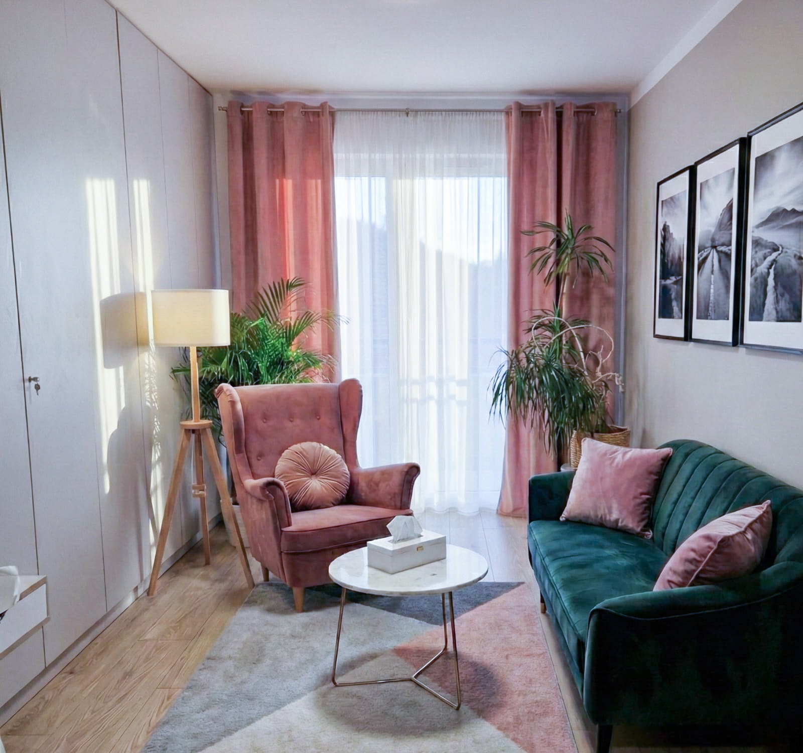 Przytulny gabinet terapeutyczny: fotel uszak, zielona sofa z poduszkami, marmurowy stolik, lampa na trójnogu, obrazy na ścianie i rośliny doniczkowe.