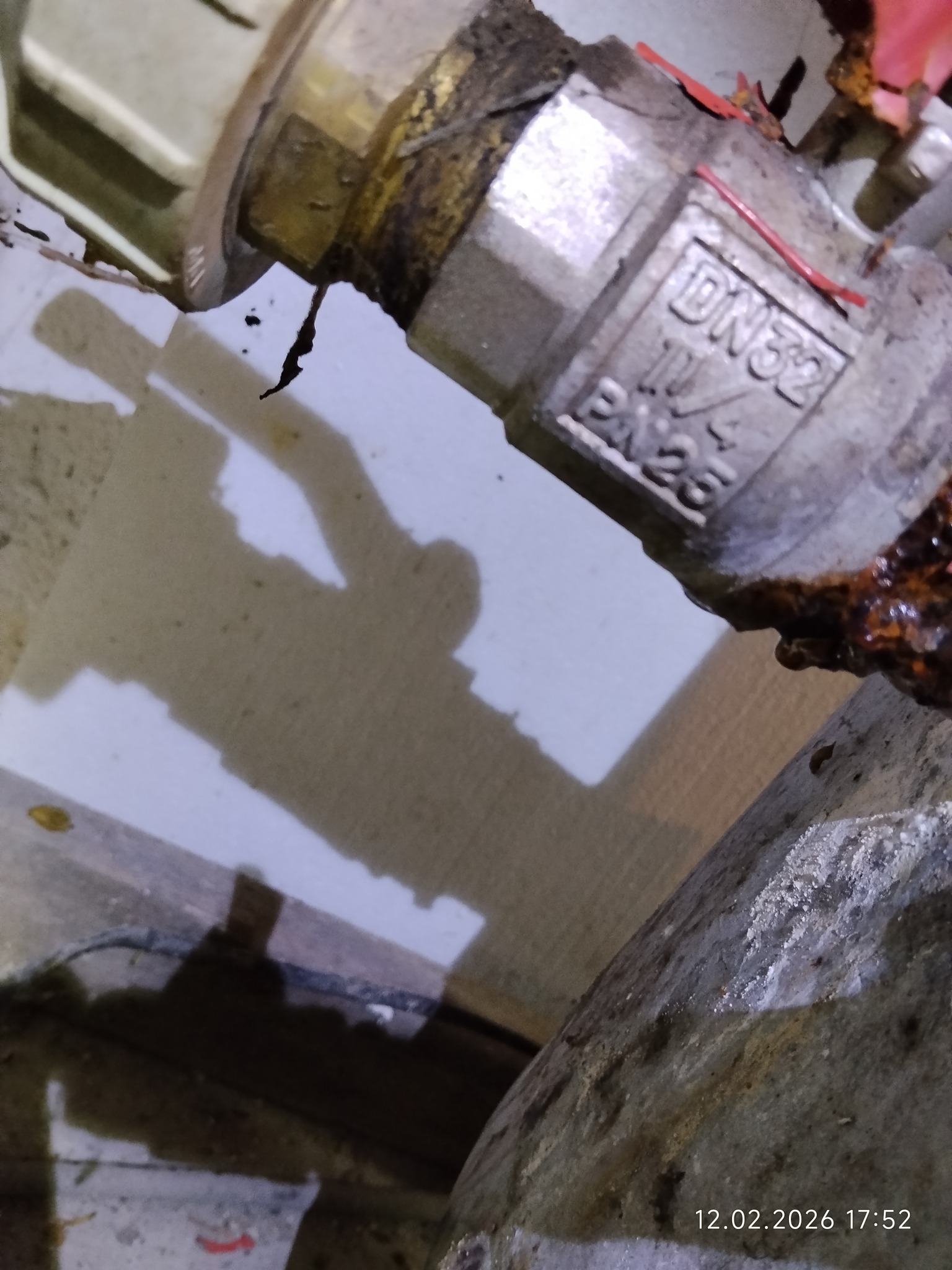 Zardzewiały zawór DN32 z widocznymi śladami korozji i wycieków, sfotografowany z bliska pod kątem, ukazujący detale uszkodzeń i potencjalną awarię instalacji.