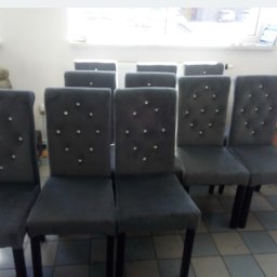 MS Glamour Usługi tapicerskie - Szereg krzeseł z szarej tkaniny, zdobionych kryształkami, ustawionych w rzędzie na tle jasnego pomieszczenia. Widoczne detale wykończenia i symetryczny układ.