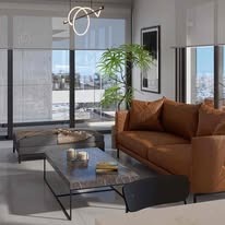 Nowoczesny salon z brązową skórzaną sofą, marmurowym stolikiem kawowym i minimalistyczną lampą wiszącą. Duże okna z roletami wpuszczają naturalne światło.