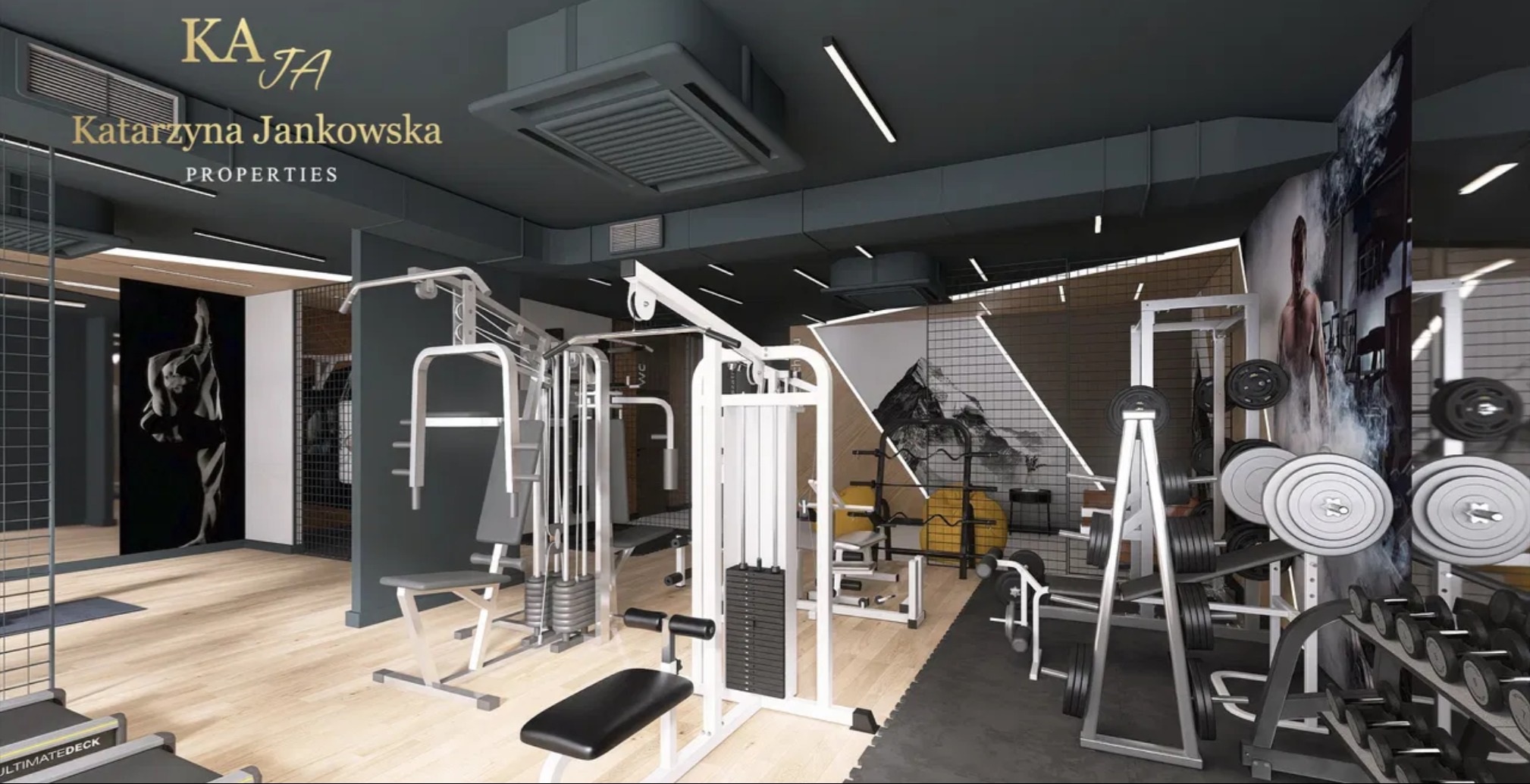 Nowoczesna siłownia z różnorodnym sprzętem do ćwiczeń, w stonowanej kolorystyce szarości i bieli, z akcentami graficznymi na ścianach. Widoczne logo firmy.