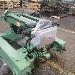 Elektryczny wciągnik linowy KVAT ELMOT z wózkiem jednoszynowym, w odcieniach zieleni, przeznaczony do suwnic przemysłowych. Widoczne kable i skrzynka sterownicza.