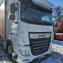 BioTech Aneta Telążka - Biała ciężarówka DAF XF na ośnieżonym terenie, z czerwoną ładowarką teleskopową Massey Ferguson w tle. Widoczna tablica rejestracyjna i logo DAF.