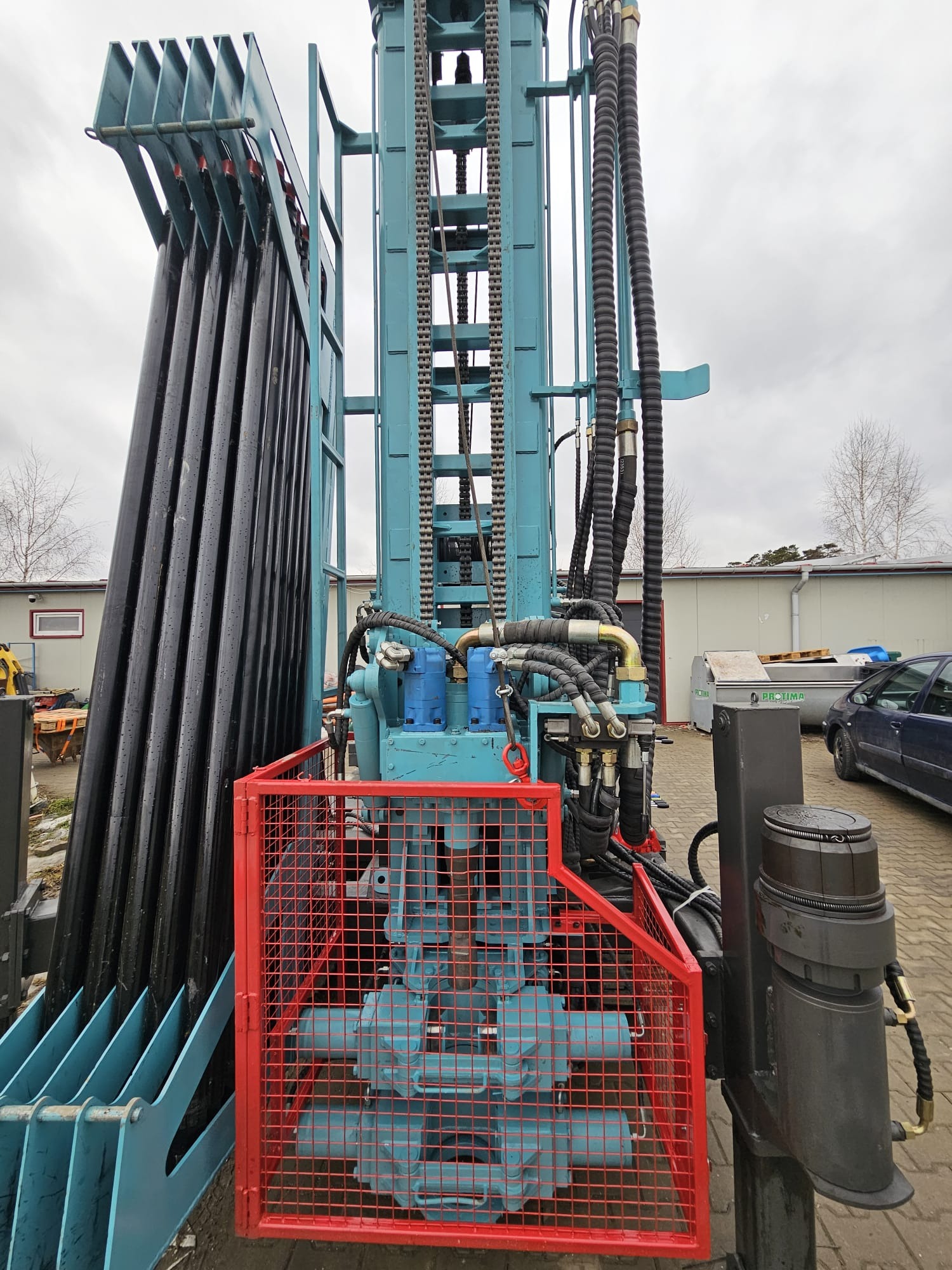 Wiertnica do studni głębinowych w Bełchatowie. Widoczne rury wiertnicze, hydraulika i zabezpieczenia. Sprzęt gotowy do pracy.