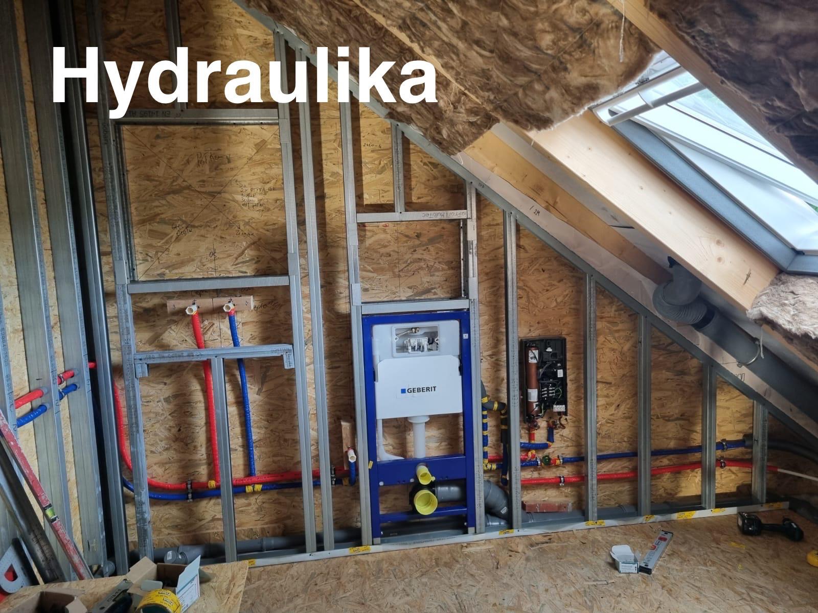 Montaż instalacji wodno-kanalizacyjnej Geberit w łazience na poddaszu, widoczne rury w kolorze niebieskim i czerwonym, stelaż podtynkowy i okno dachowe.