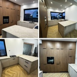 JUST.LUXURY BARBARA GROBLICKA, MONIKA GÓRNIAK-SEROWIK S.C. - Nowoczesna kuchnia z drewnianymi frontami i wyspą, minimalistyczne uchwyty, parkiet w jodełkę, duże okno z widokiem na zewnątrz, oświetlenie punktowe.