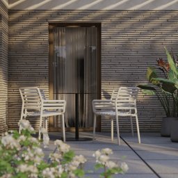 Zadaszony taras przy domu we Wrocławiu - strefa wypoczynkowa z donicami ozdobnymi, nawierzchnią tarasową i klimatycznym oświetleniem.